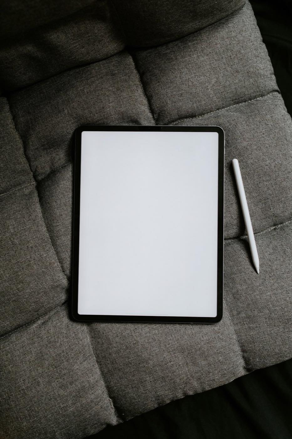 Tablette blanche posée sur un textile gris
